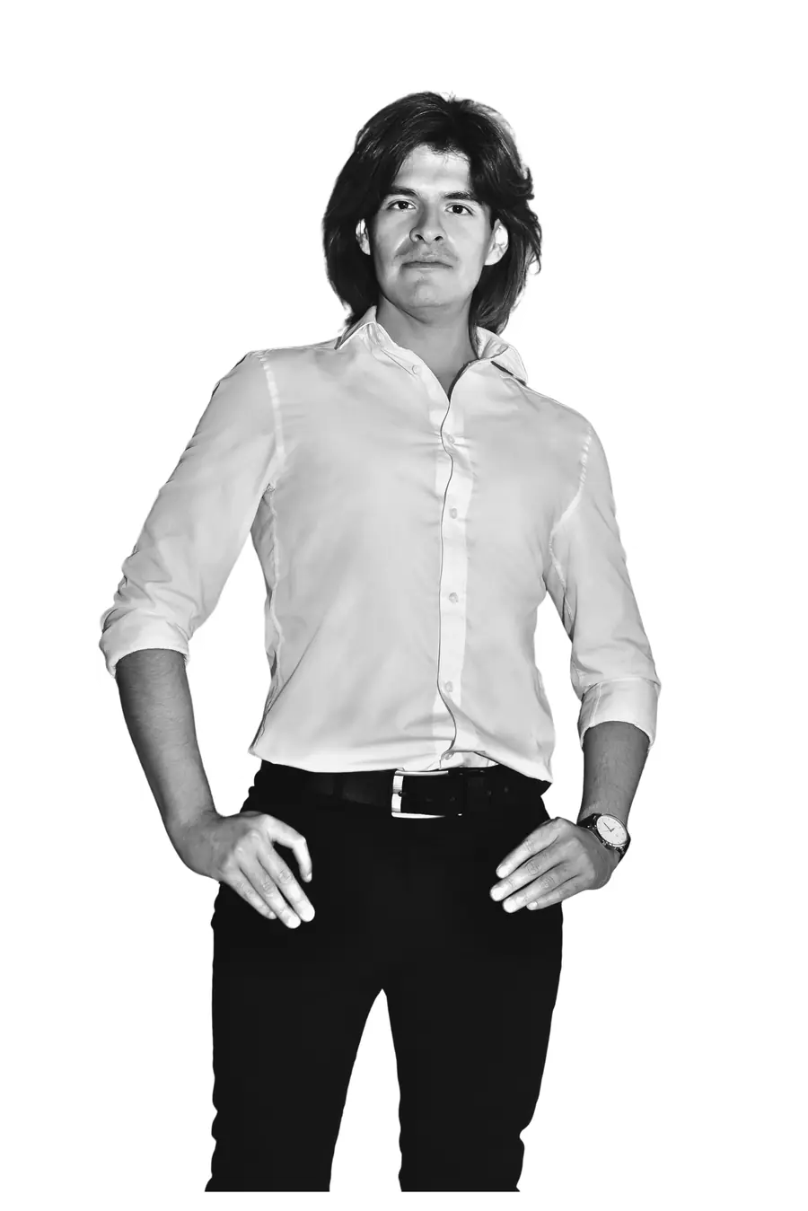 Confident black-and-white portrait of Juan Diego Saire standing with purpose, hands on hips in a white shirt.